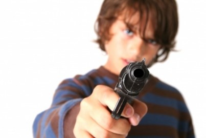 child with gun isolated on white. kid playing gangster or criminal